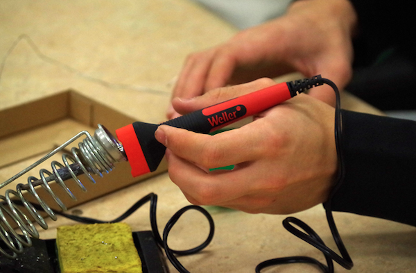 A soldering iron in its holder.