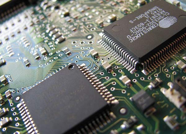 A close-up of two integrated circuits and surface-mount capacitors on a printed circuit board. 