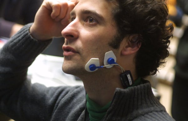 A man trialling a wearable magnetic stimulation device, whose sensors are attached to his lower jaw