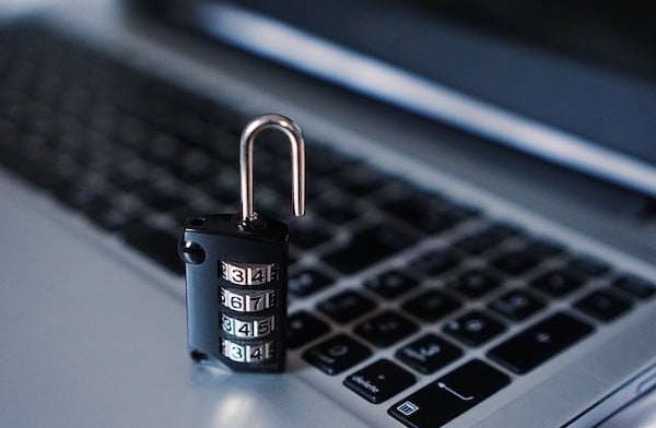 A small padlock sitting on a laptop